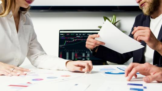 Deals being made at a desk with a man and woman