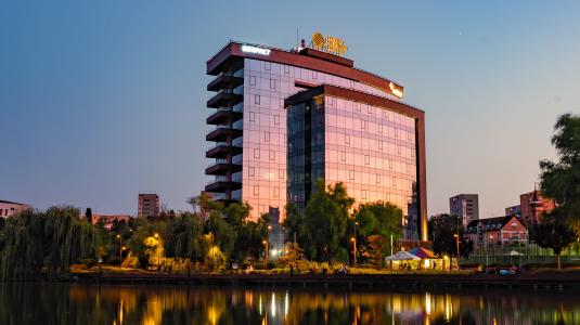 hotel in with lake in front of it at dawn