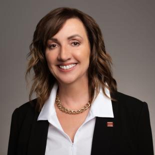 Woman with brown hair and a black suit